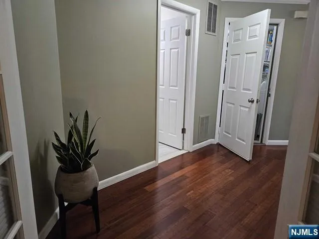 a view of a hallway with wooden floor and a chair
