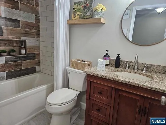 a bathroom with a granite countertop toilet sink and mirror