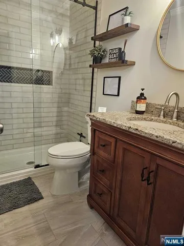 a bathroom with a granite countertop toilet sink and mirror