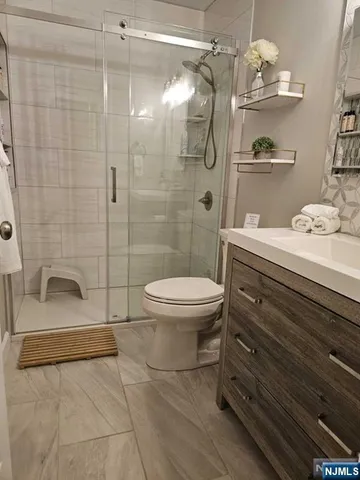 a bathroom with a sink a toilet and shower