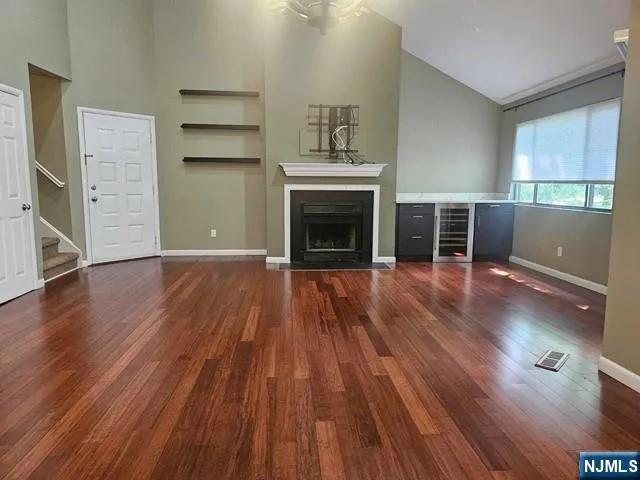 an empty room with wooden floor and fireplace