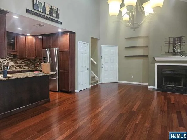 a view of a kitchen with a sink a refrigerator and wooden floor