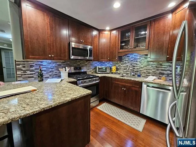 a kitchen with stainless steel appliances granite countertop a sink stove and refrigerator