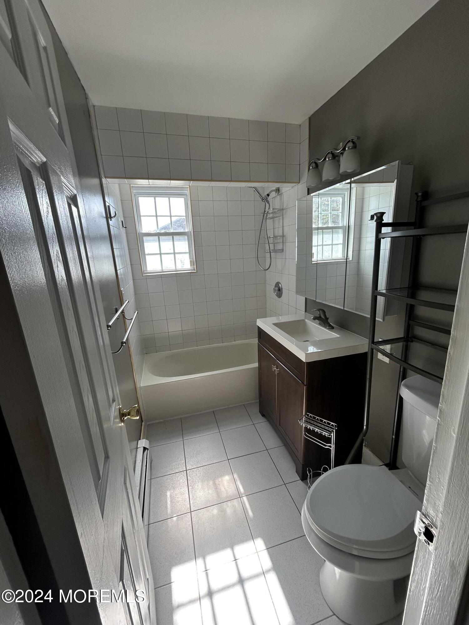 12 Manchester Court, Unit C Freehold, NJ 07728 - Photo 11 of 16 a bathroom with a sink a toilet a mirror and shower