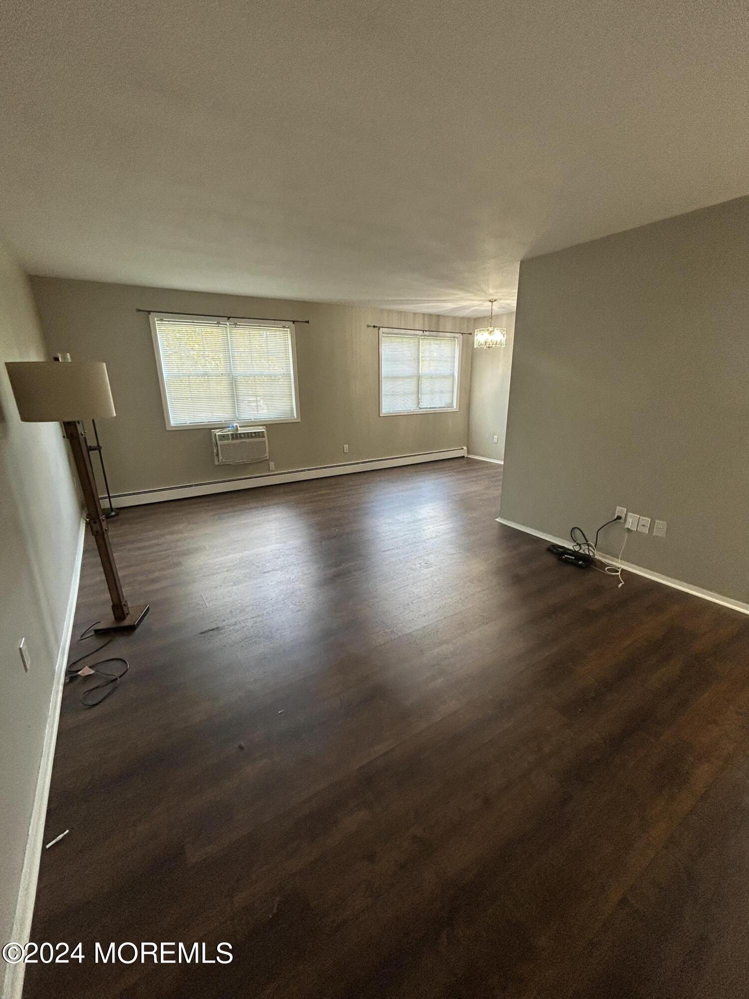 12 Manchester Court, Unit C Freehold, NJ 07728 - Photo 12 of 16 an empty room with wooden floor and windows