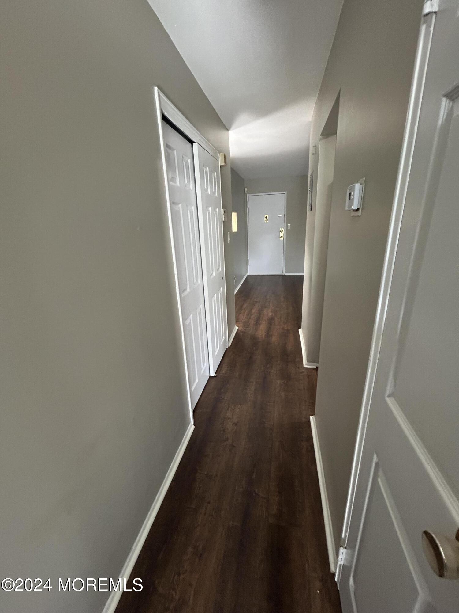 12 Manchester Court, Unit C Freehold, NJ 07728 - Photo 13 of 16 a view of a hallway with wooden floor and staircase