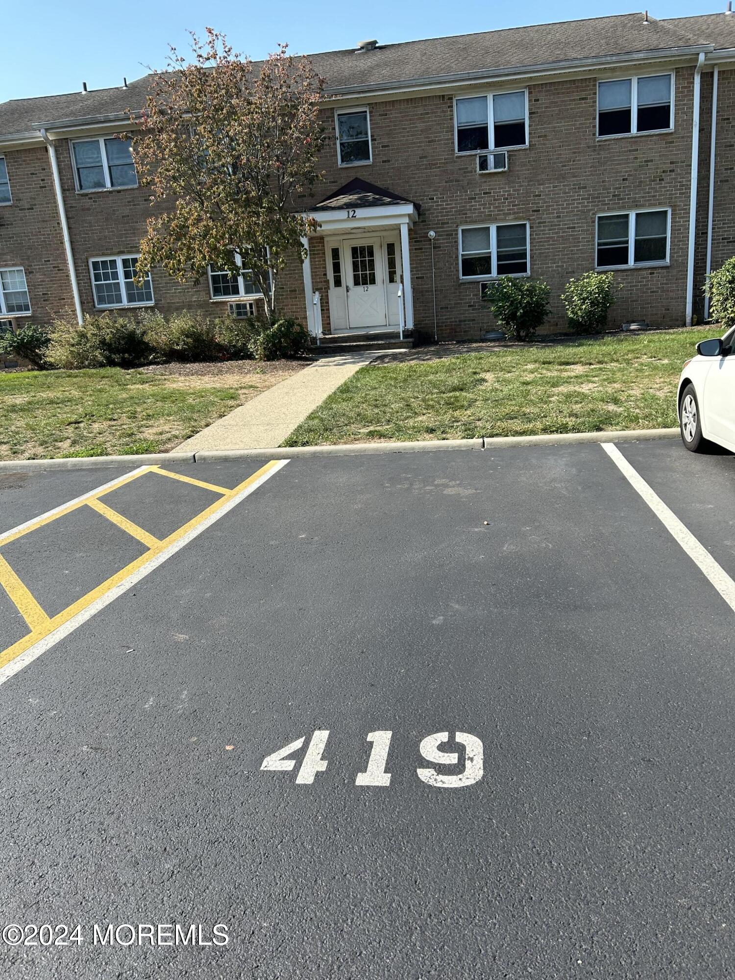 12 Manchester Court, Unit C Freehold, NJ 07728 - Photo 2 of 16 a front view of a house with a yard