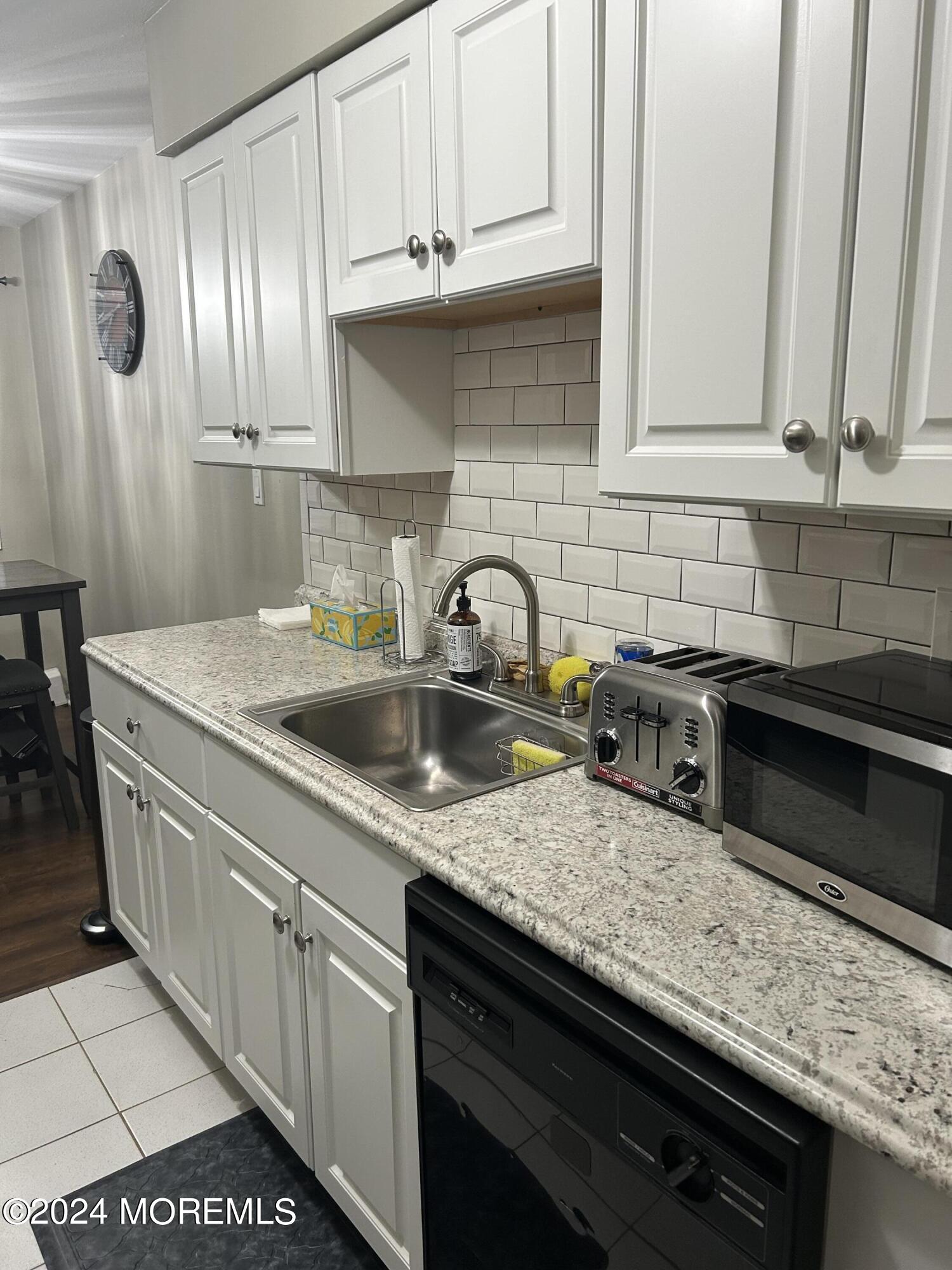 12 Manchester Court, Unit C Freehold, NJ 07728 - Photo 5 of 16 a kitchen with stainless steel appliances granite countertop a sink stove and cabinets
