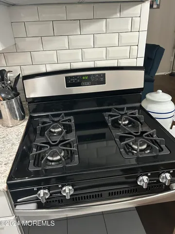 a stove sitting inside of a kitchen with white cabinets