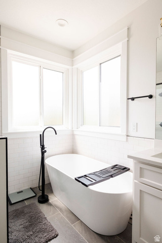 924 Country Lane Farmington, UT 84025 - Photo 29 of 91 Freestanding soaking tub with a matte black floor-mounted faucet, set against a white subway tile wainscoting
