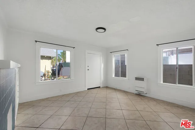 a bathroom with a granite countertop sink a toilet and a window