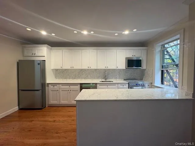 a kitchen with stainless steel appliances granite countertop a refrigerator sink and stove