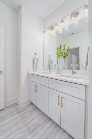 a bathroom with a double vanity sink and a mirror