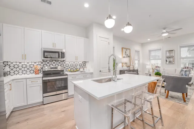 a kitchen with a white cabinets and chairs