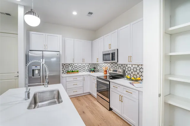 a kitchen with white cabinets and refrigerator