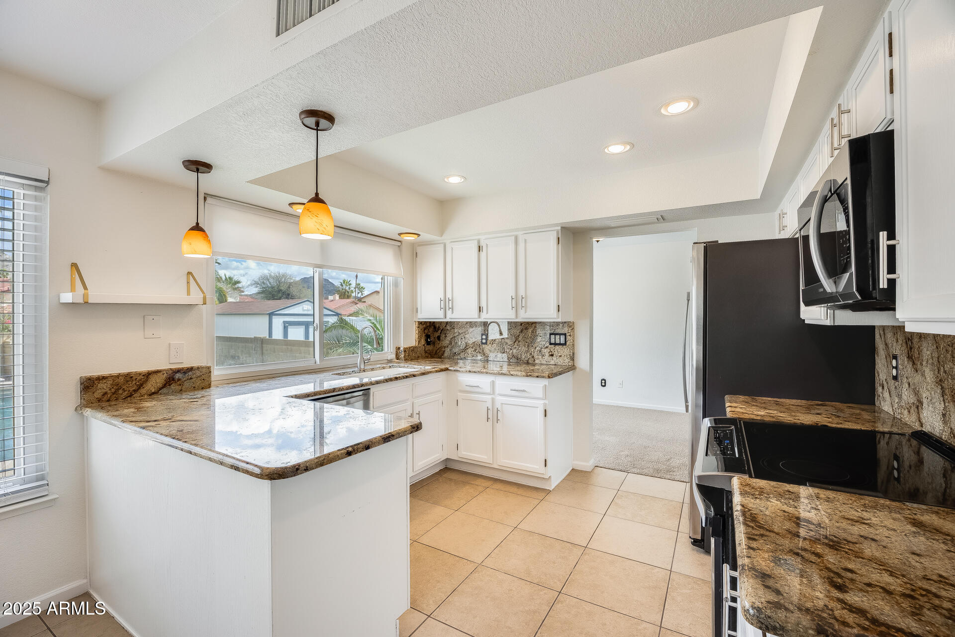 1929 East Redfield Road Phoenix, AZ 85022 - Photo 14 of 58 a kitchen with stainless steel appliances granite countertop a sink and a refrigerator