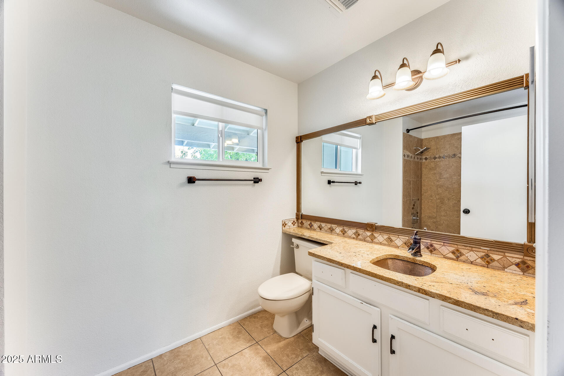 1929 East Redfield Road Phoenix, AZ 85022 - Photo 37 of 58 a bathroom with a granite countertop sink a toilet and a mirror