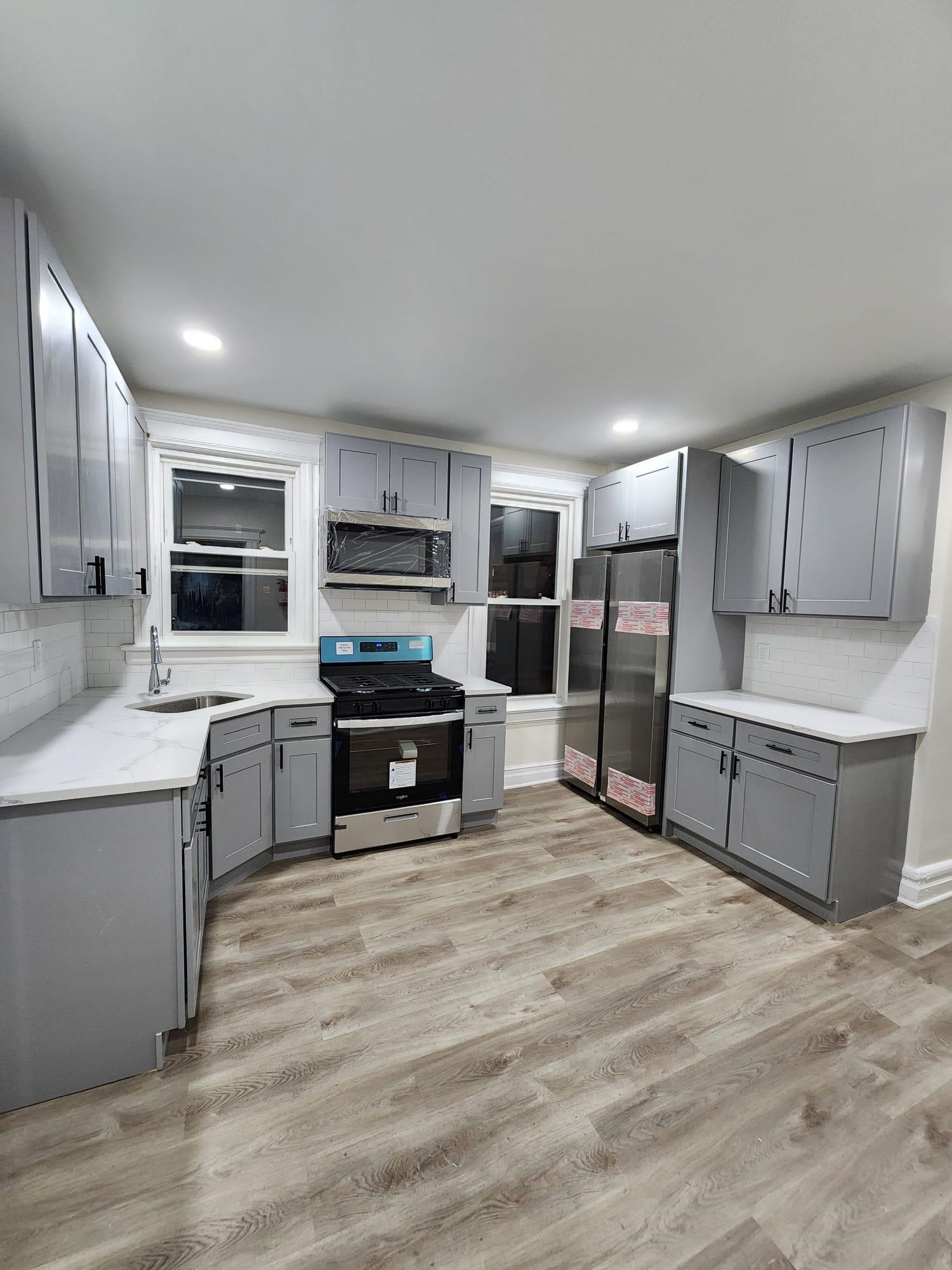 65 Halstead Street, Unit 2 Kearny, NJ 07032 - Photo 1 of 16 a large kitchen with cabinets wooden floor and stainless steel appliances