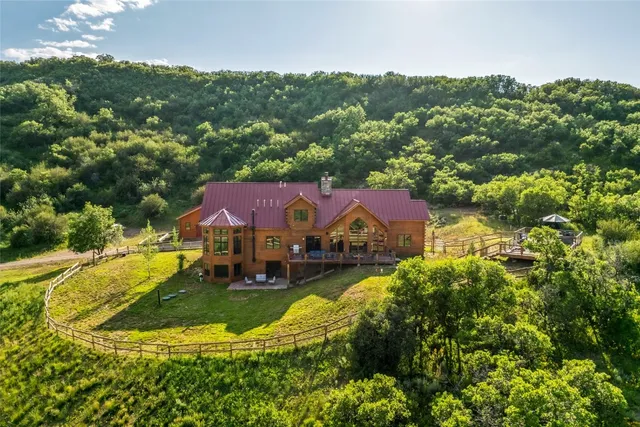 an aerial view of residential houses with outdoor space and trees