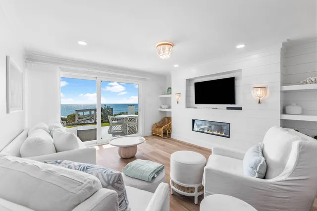 a living room with furniture a flat screen tv and a large window
