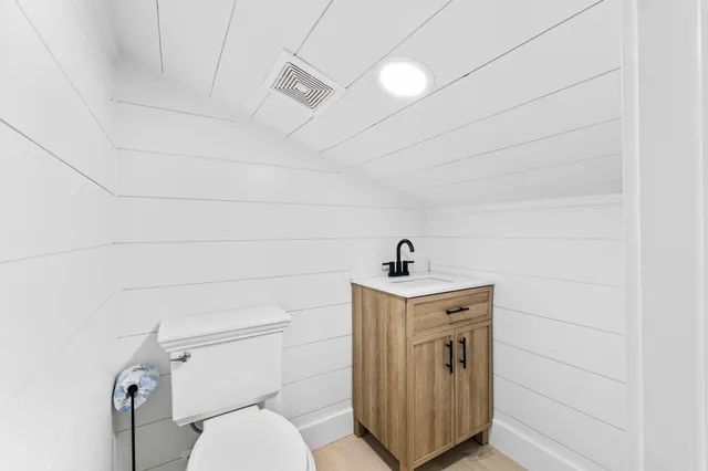 a bathroom with a toilet a sink and mirror