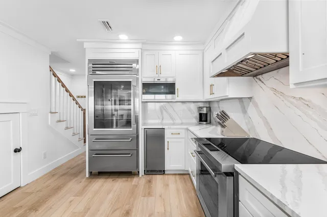 a kitchen with stainless steel appliances a refrigerator and a stove top oven