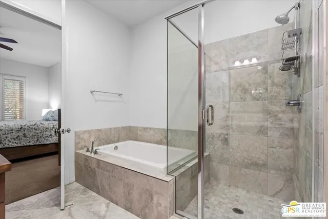 a bathroom with a granite countertop bathtub shower and mirror