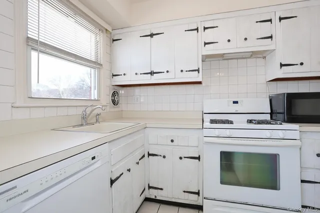 a kitchen with cabinets appliances a sink and a window