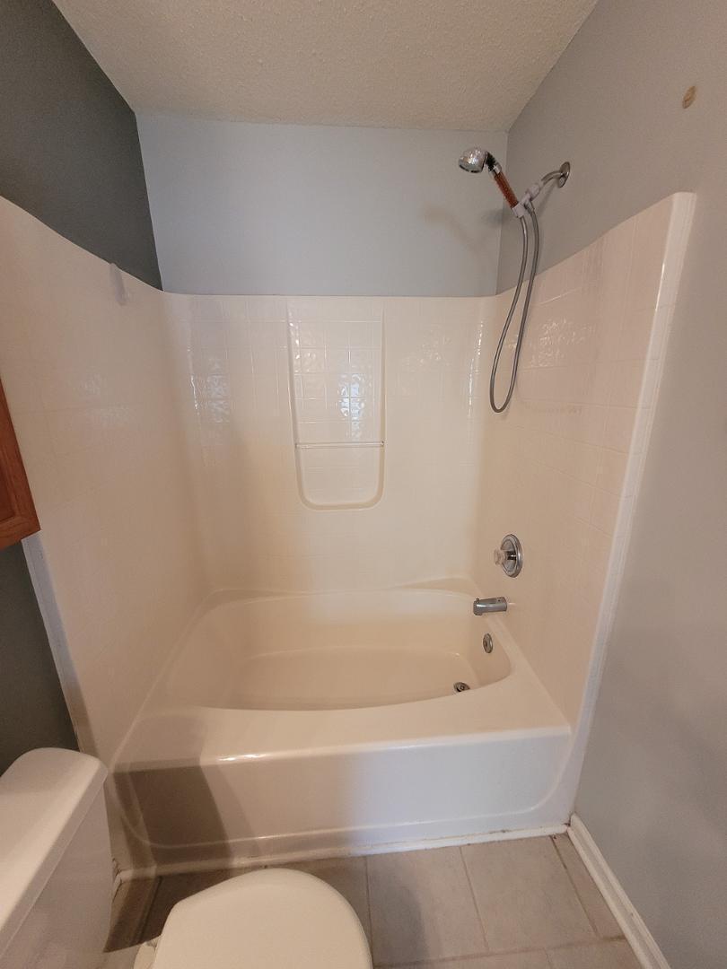 5517 Roan Place Raleigh, NC 27613 - Photo 18 of 35 a bathroom with a bathtub and toilet