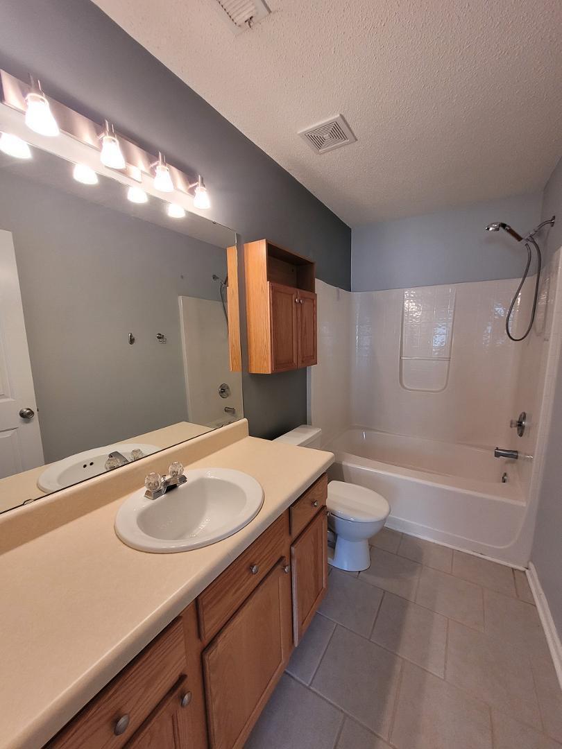 5517 Roan Place Raleigh, NC 27613 - Photo 19 of 35 a bathroom with a sink a toilet a mirror and bathtub
