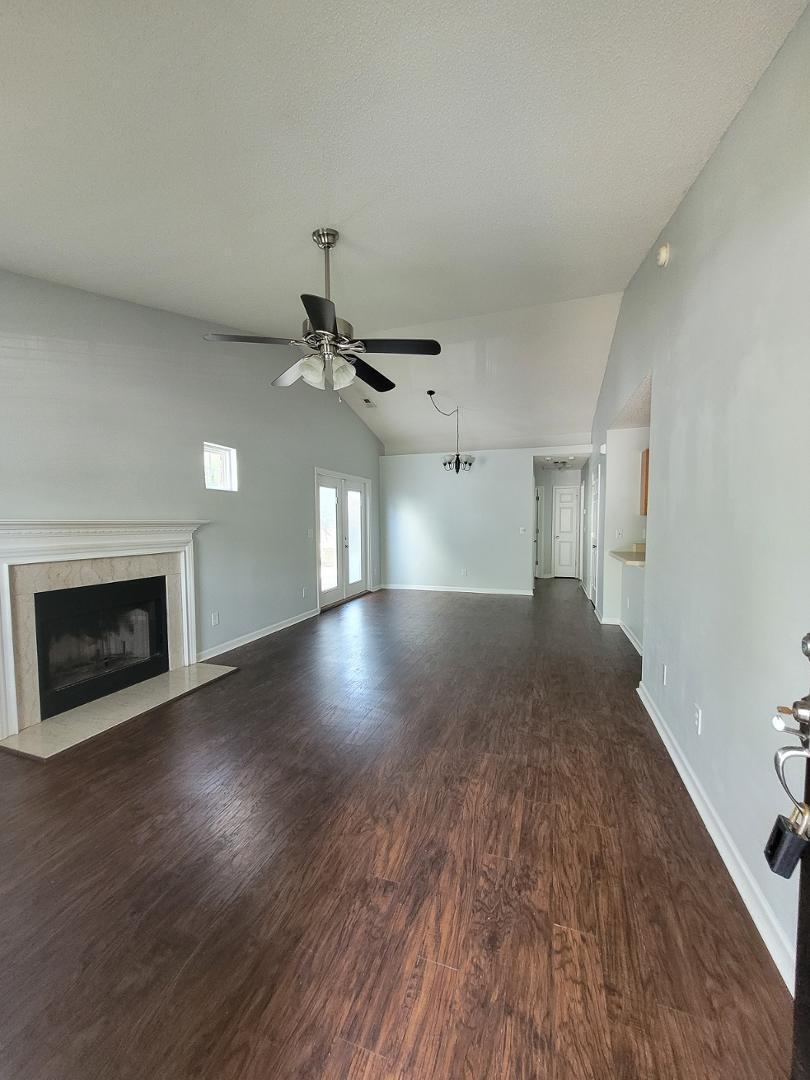 5517 Roan Place Raleigh, NC 27613 - Photo 2 of 35 an empty room with wooden floor fireplace and windows
