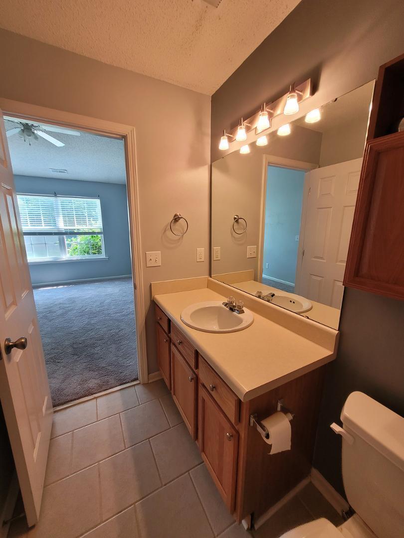 5517 Roan Place Raleigh, NC 27613 - Photo 21 of 35 a bathroom with a sink a toilet a mirror and vanity