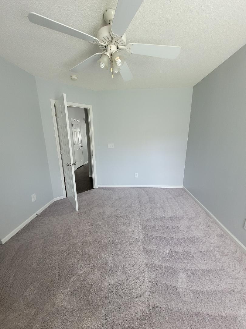 5517 Roan Place Raleigh, NC 27613 - Photo 23 of 35 a view of an empty room with a chandelier fan