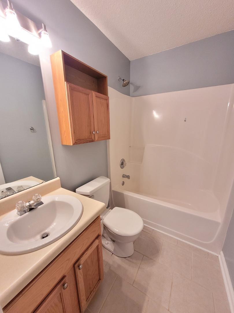 5517 Roan Place Raleigh, NC 27613 - Photo 26 of 35 a bathroom with a sink a toilet and shower