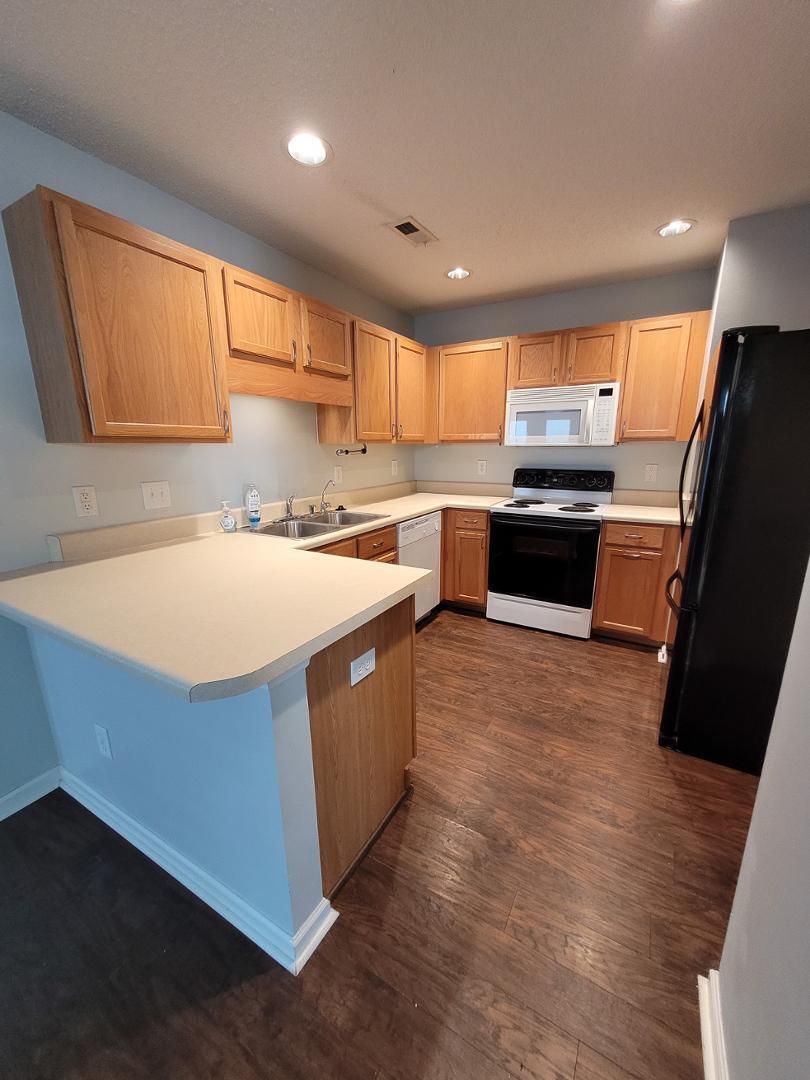 5517 Roan Place Raleigh, NC 27613 - Photo 9 of 35 a kitchen with stainless steel appliances a sink a stove a refrigerator cabinets and a window