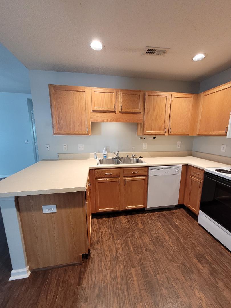 5517 Roan Place Raleigh, NC 27613 - Photo 10 of 35 a kitchen with wooden floors and white stainless steel appliances