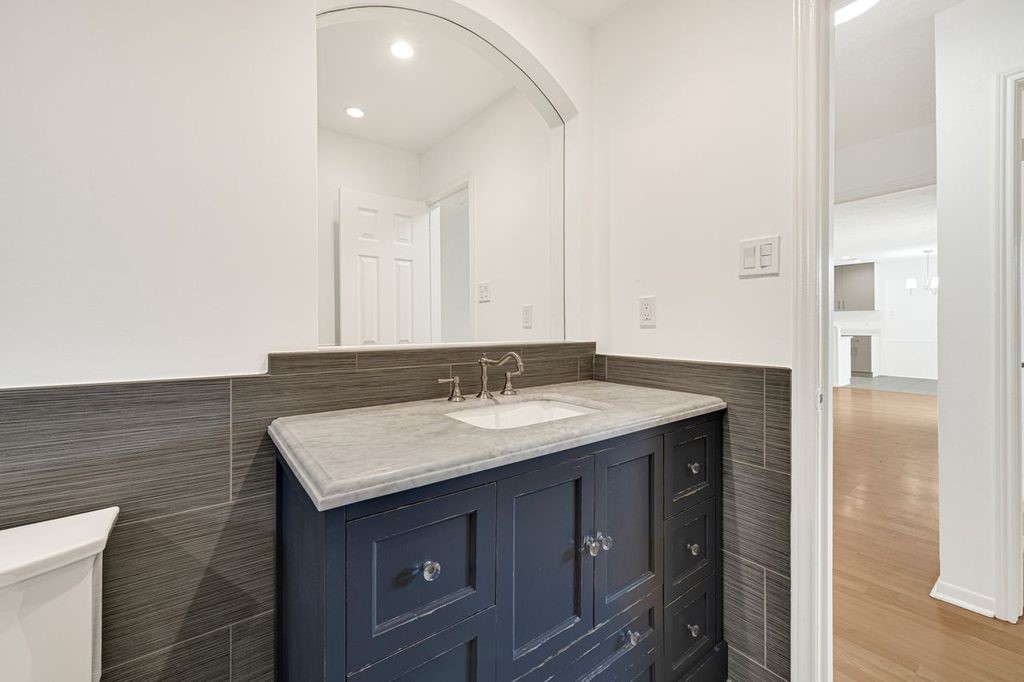 4518 Seneca Street Pasadena, TX 77504 - Photo 15 of 26 a bathroom with a granite countertop sink and a mirror