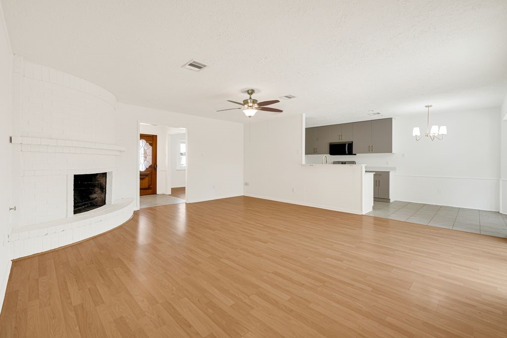 4518 Seneca Street Pasadena, TX 77504 - Photo 10 of 26 a view of a livingroom with a fireplace a ceiling fan and wooden floor