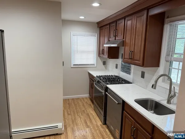a kitchen with granite countertop a sink stove and refrigerator