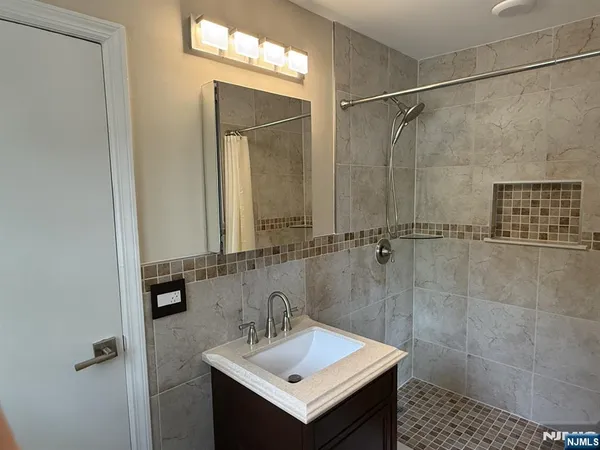 a bathroom with a sink mirror and shower