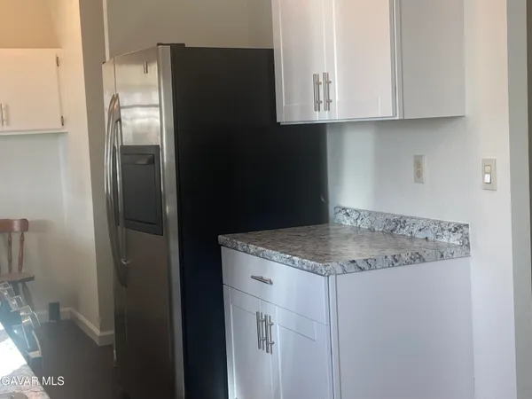 an empty room with wooden floor cabinet and windows