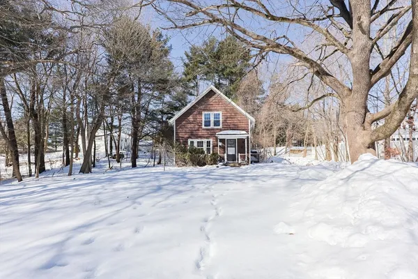 a front view of a house with a yard covered with snow