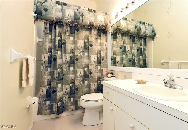 a bathroom with a sink a toilet and shower curtain