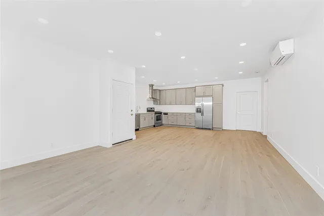 a view of empty room with kitchen and window