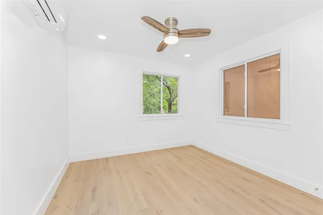 an empty room with window and ceiling fan