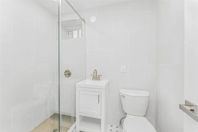 a bathroom with a toilet a sink and mirror
