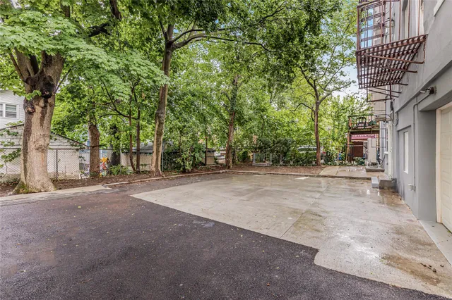 a view of a yard with plants and trees