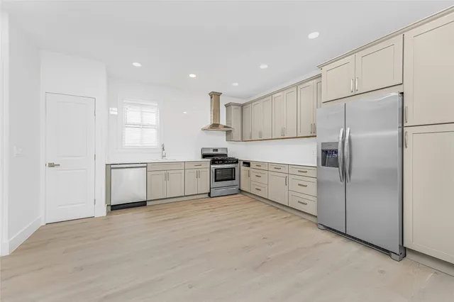 a kitchen with white cabinets and stainless steel appliances