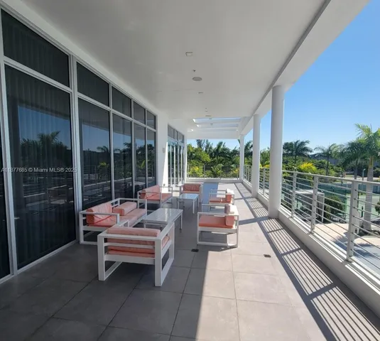a balcony with chairs and with potted plants