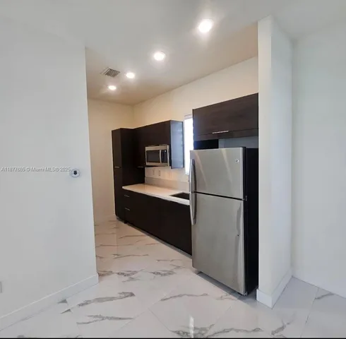 a kitchen with stainless steel appliances a refrigerator and a stove top oven